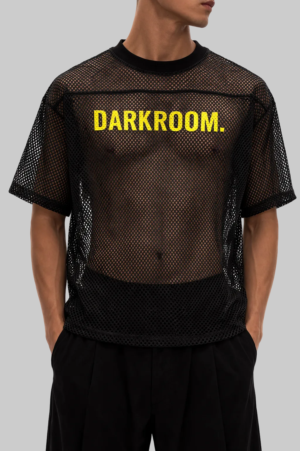 Person wearing a black mesh shirt with 'DARKROOM.' text on a white background
