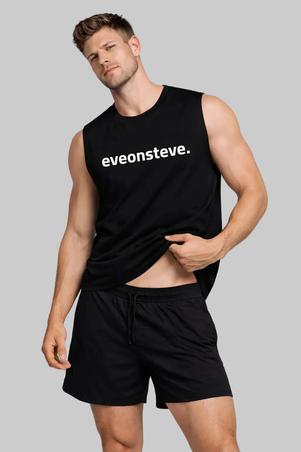 Man wearing a black sleeveless shirt with 'eveonsteve.' text and black shorts on a white background