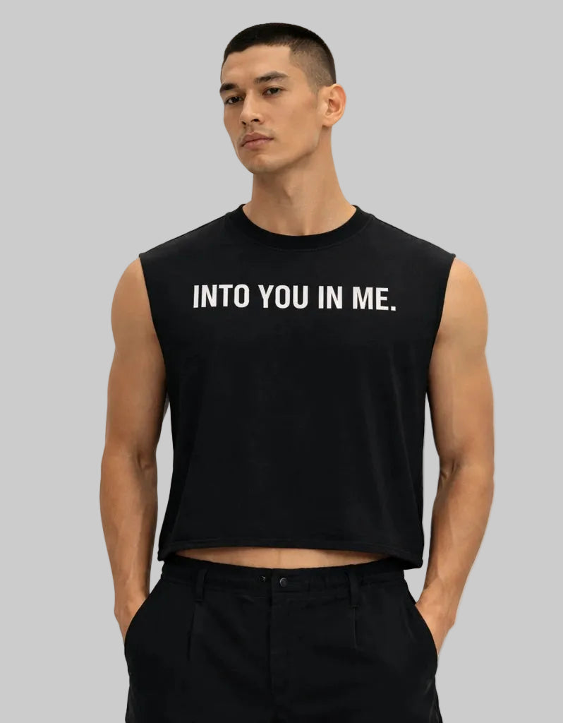 Man wearing a black sleeveless shirt with text on a white background